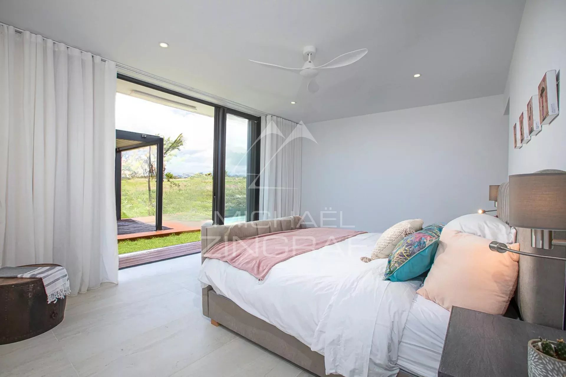 Chambre d'une villa de luxe avec vue sur le golf, décor moderne et lumineux.
