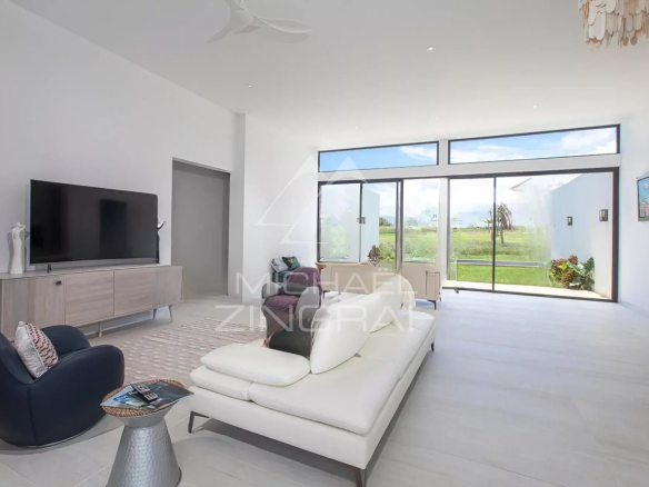 Intérieur d'une villa de luxe avec un salon moderne et lumineux, vue sur le jardin.