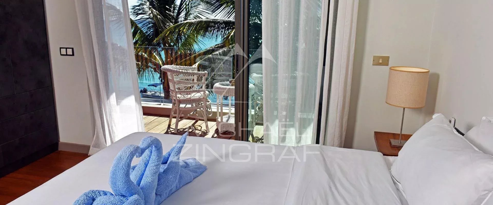 Room with sea view in Pereybere Room in an apartment with sea view in Pereybere, bed and balcony with chairs.