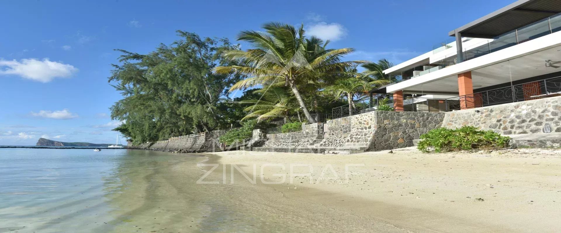 Seaside apartment in Pereybere Beach with a seaside apartment in Pereybere, surrounded by palm trees and calm water.