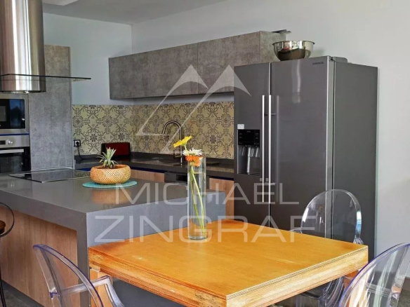 Modern kitchen with a central island and stainless steel appliances in an apartment in Pereybere.