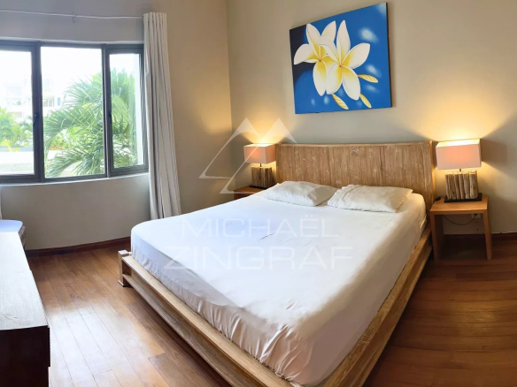 Chambre d'un appartement avec lit double et décoration sobre à Bain Bœuf.