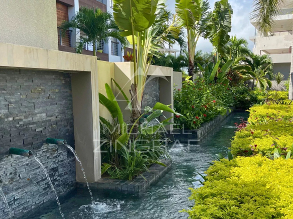 Jardin paysager avec fontaine et végétation luxuriante dans une résidence à Bain Bœuf.