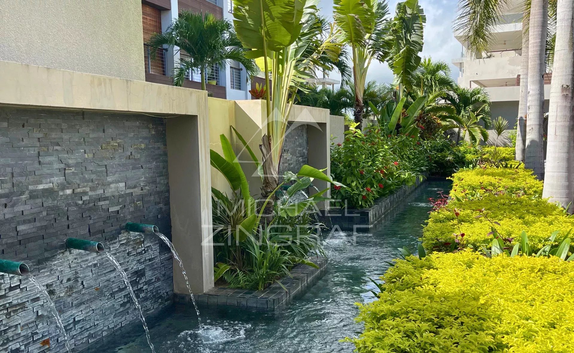 Jardin de la résidence à Bain Bœuf Jardin paysager avec fontaine et végétation luxuriante dans une résidence à Bain Bœuf.