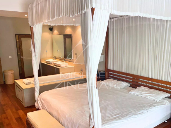 Chambre d'un appartement élégant avec lit à baldaquin et salle de bain attenante.