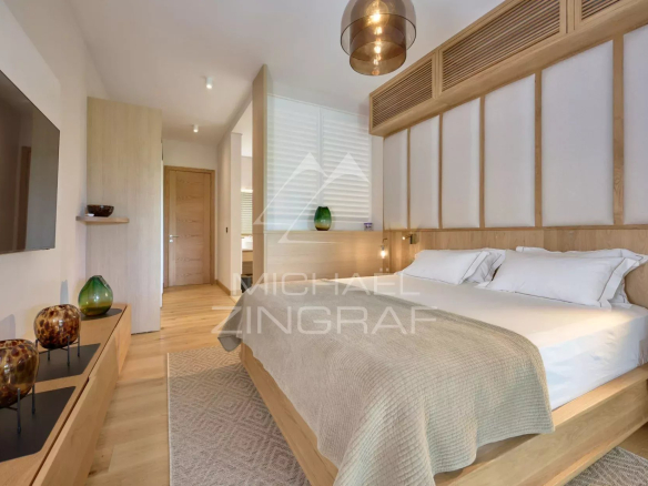 Elegant room with double bed, wooden decor and natural light.