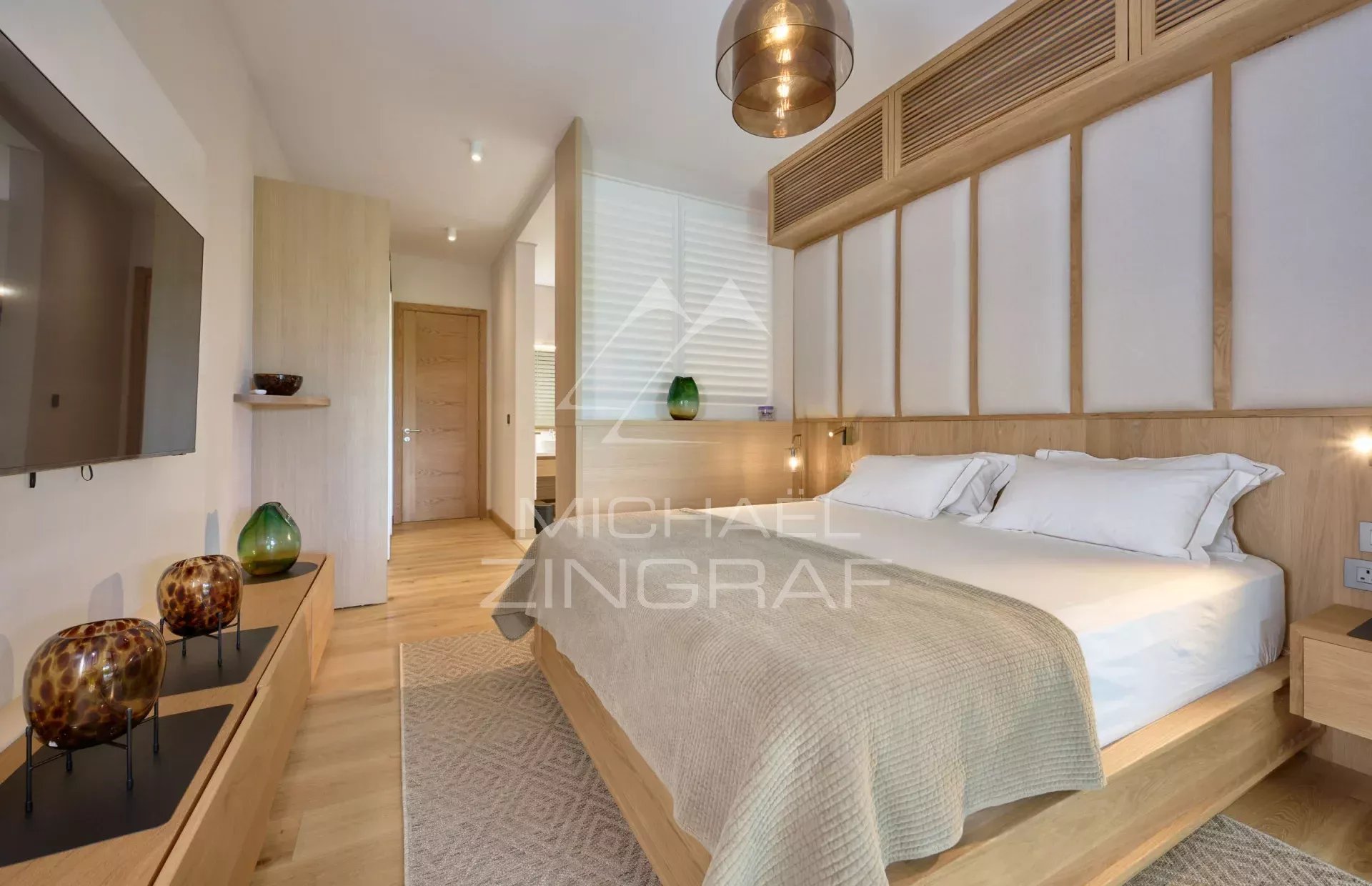 Elegant room with double bed, wooden decor and natural light.