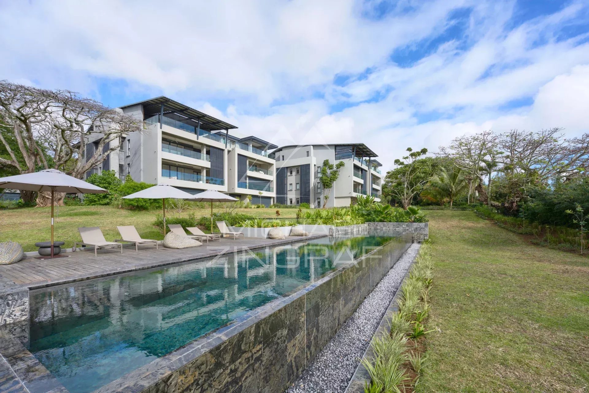View of a modern apartment with swimming pool and green spaces in Belle Vue Harel.