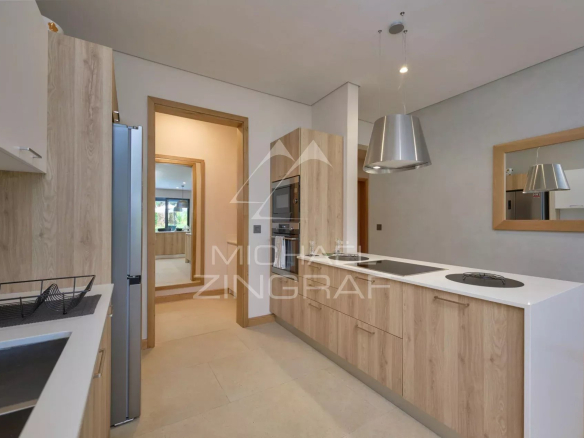 Modern kitchen with wooden elements and integrated appliances in an apartment.