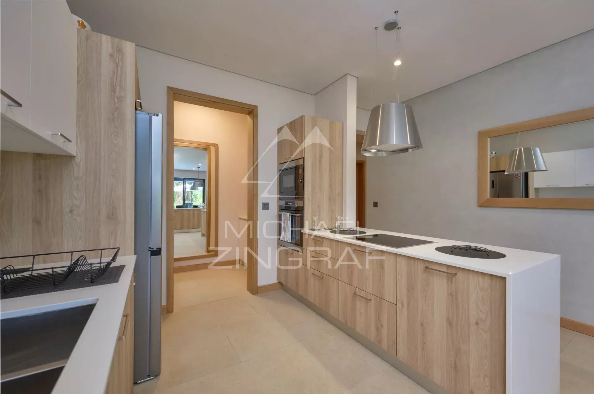 Modern kitchen with wooden elements and integrated appliances in an apartment.