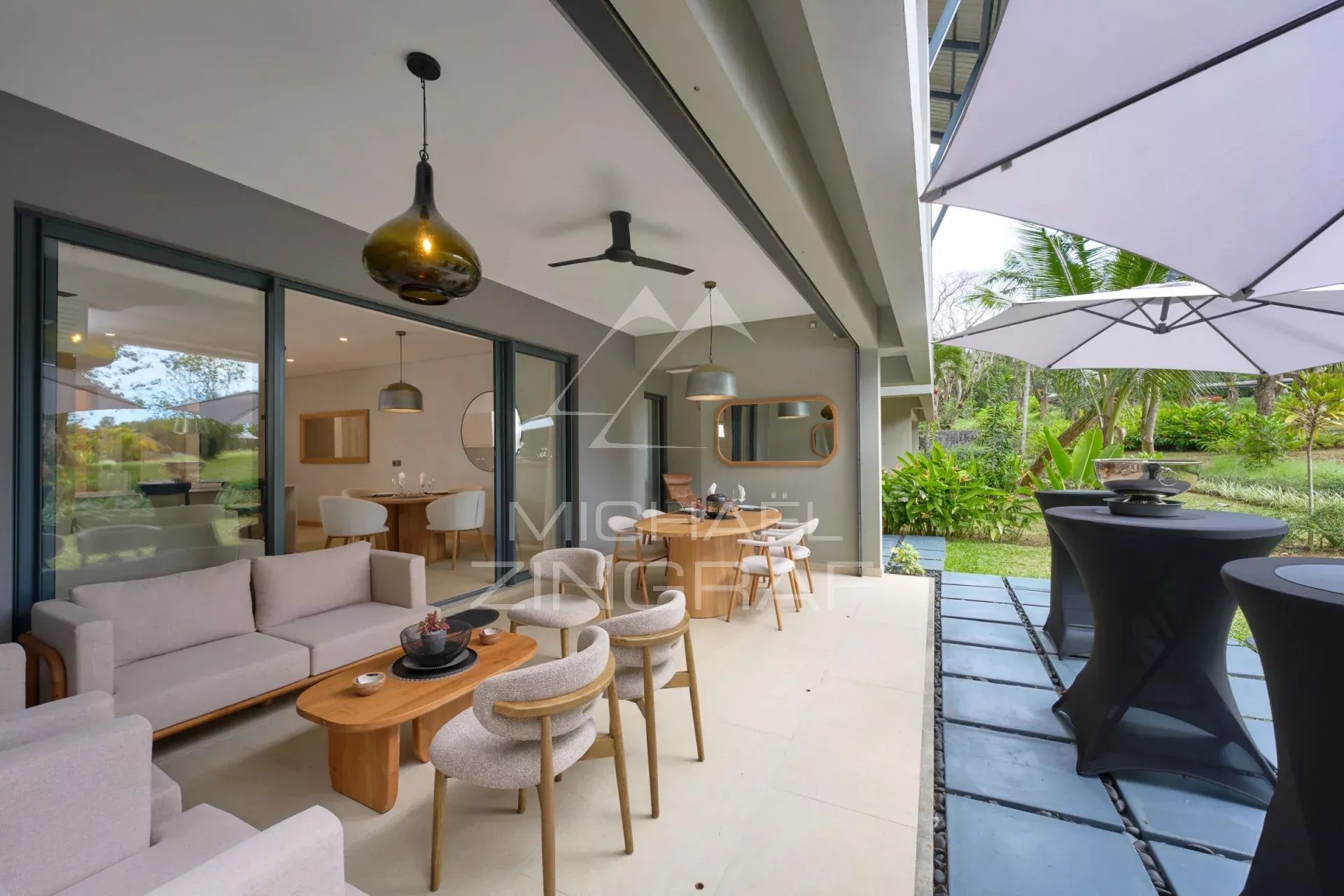 Apartment terrace with modern furniture, overlooking a green garden in Belle Vue.