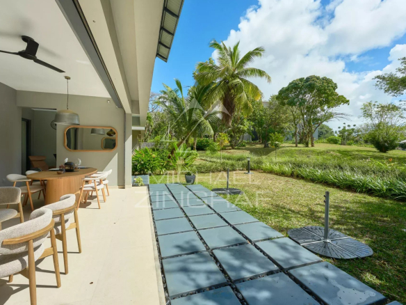 Apartment terrace with private garden in Belle Vue, surrounded by greenery and palm trees.