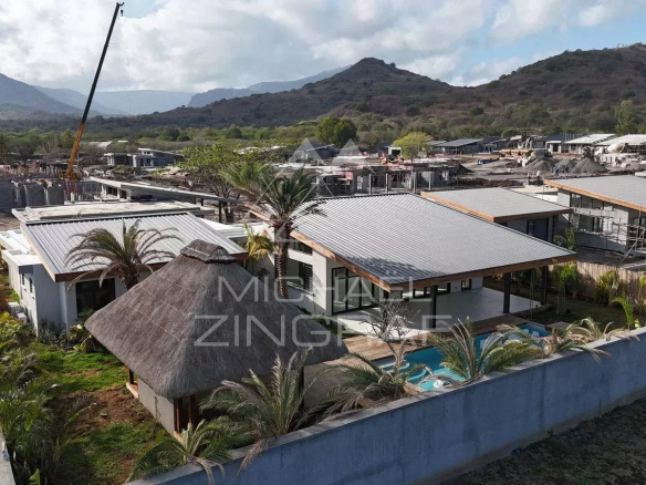 Vue aérienne d'une villa contemporaine en construction à Tamarin, entourée de nature et de montagnes.