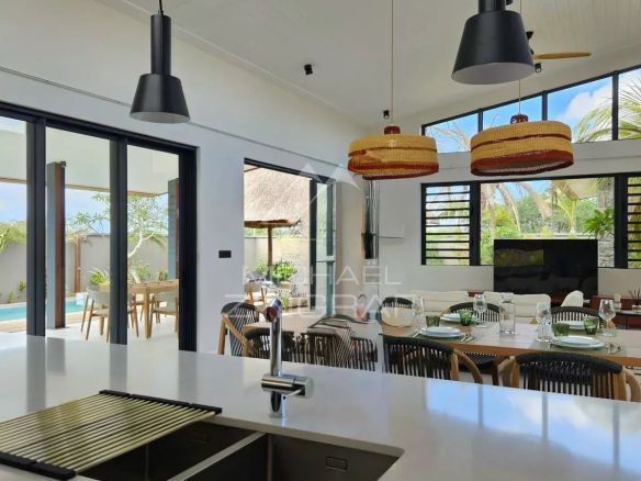 Intérieur moderne d'une villa contemporaine à Tamarin, avec cuisine ouverte et salle à manger.
