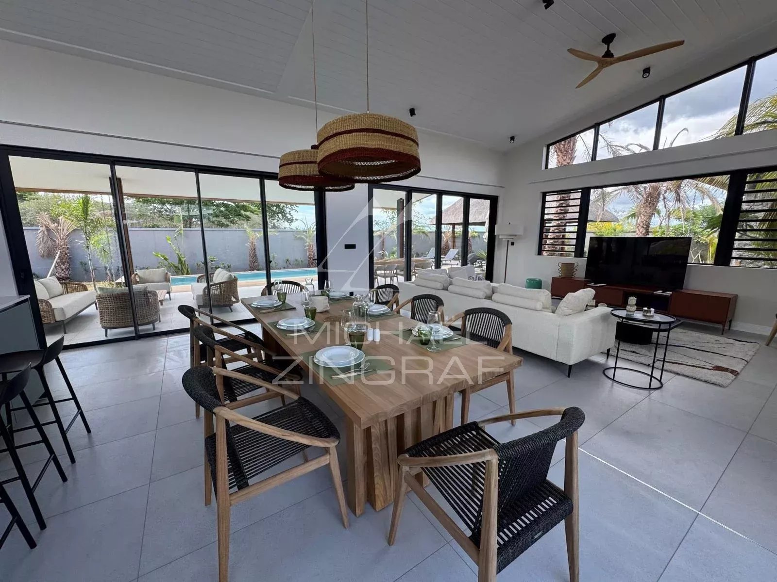 Intérieur d’une villa contemporaine à Tamarin Intérieur moderne d'une villa à Tamarin avec espace de vie ouvert, mobilier contemporain et piscine visible.