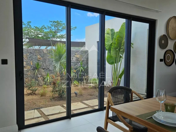 Intérieur d'une villa contemporaine à Tamarin avec grandes baies vitrées et vue sur le jardin.