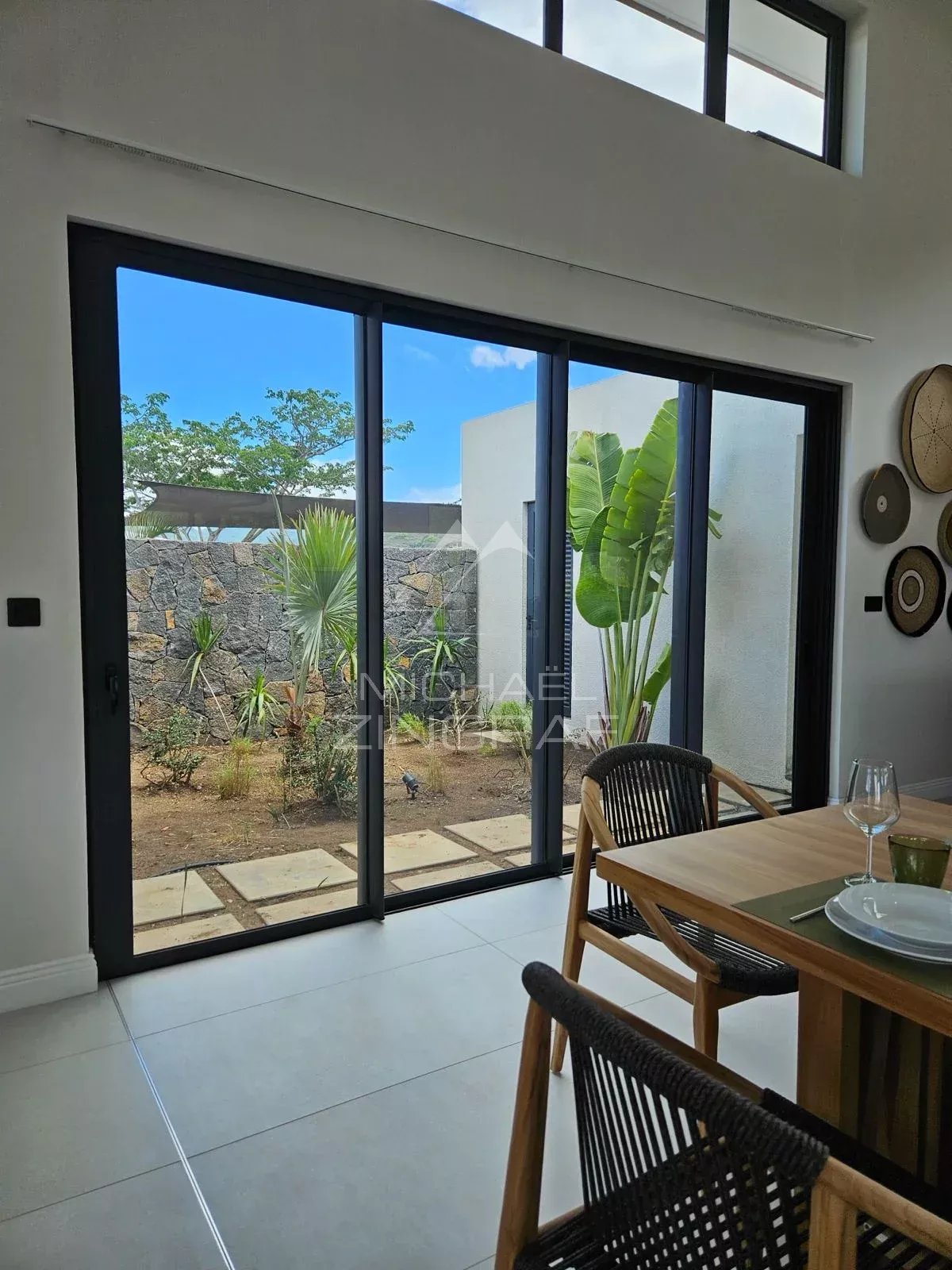 Intérieur d’une villa contemporaine à Tamarin Intérieur d'une villa contemporaine à Tamarin avec grandes baies vitrées et vue sur le jardin.