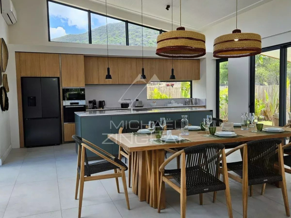 Intérieur moderne d'une villa à Tamarin avec cuisine ouverte et salle à manger élégante.