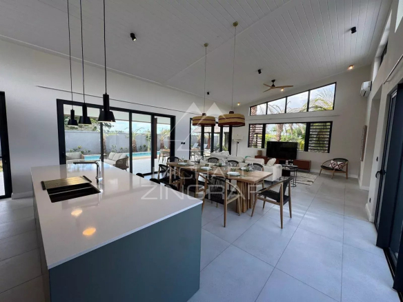 Intérieur d'une villa contemporaine à Tamarin avec cuisine ouverte et espace de vie lumineux.