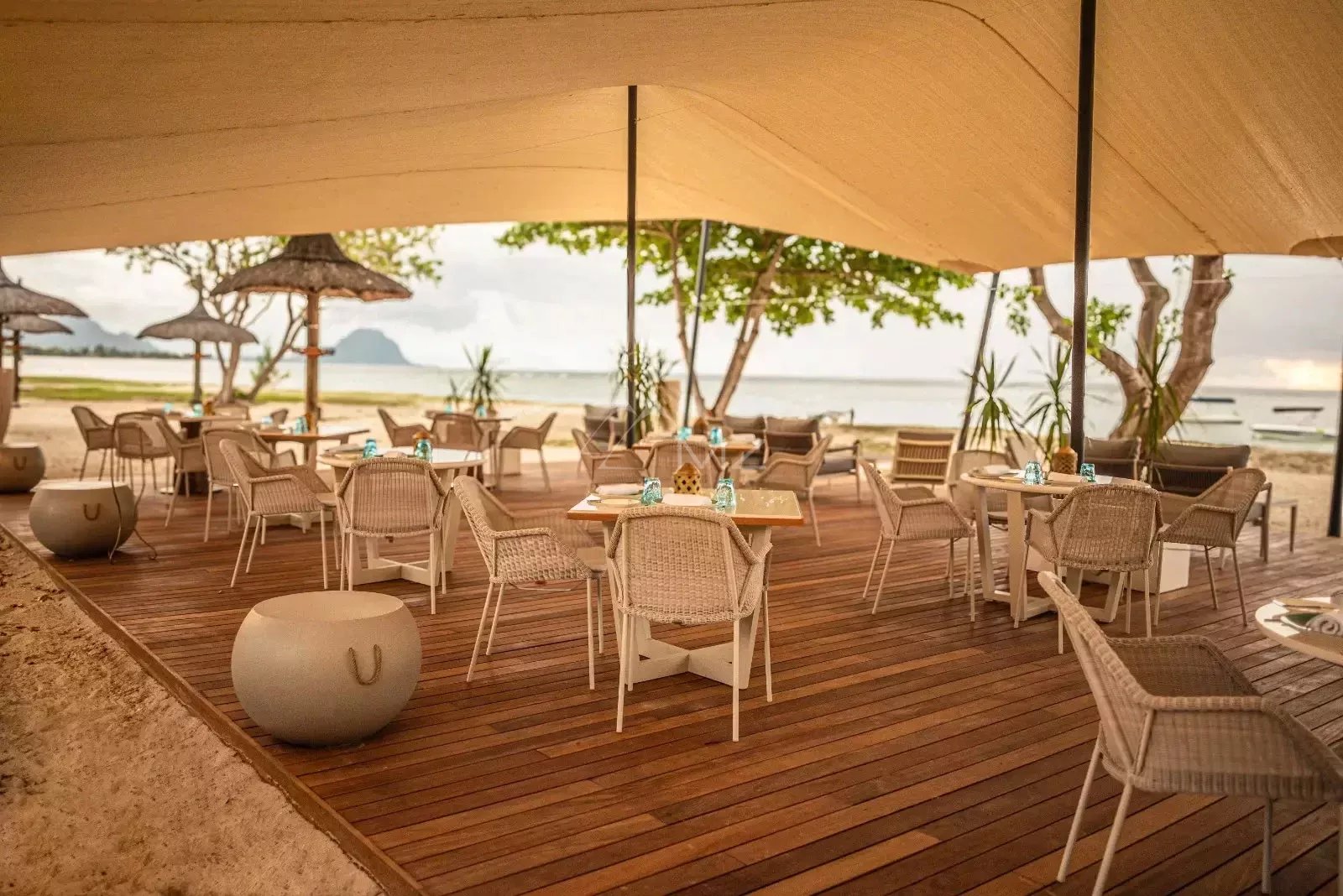 Restaurant terrace by the sea Seaside restaurant terrace with wicker tables and chairs, overlooking the beach and lagoon.