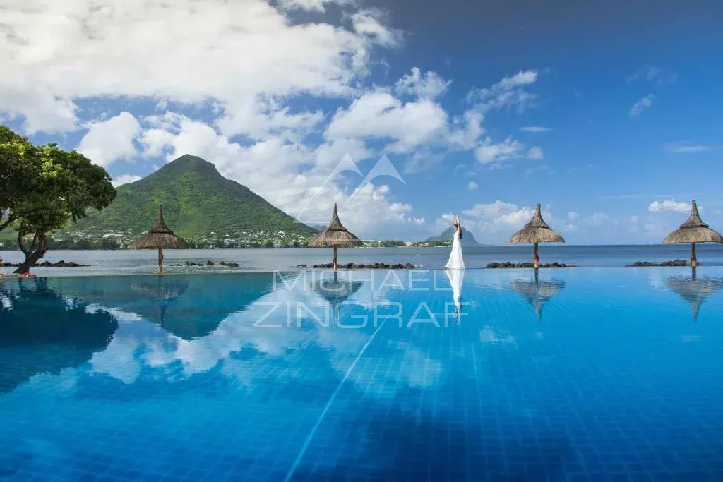 Panoramic view from a penthouse with a swimming pool and Le Morne Brabant in the background.