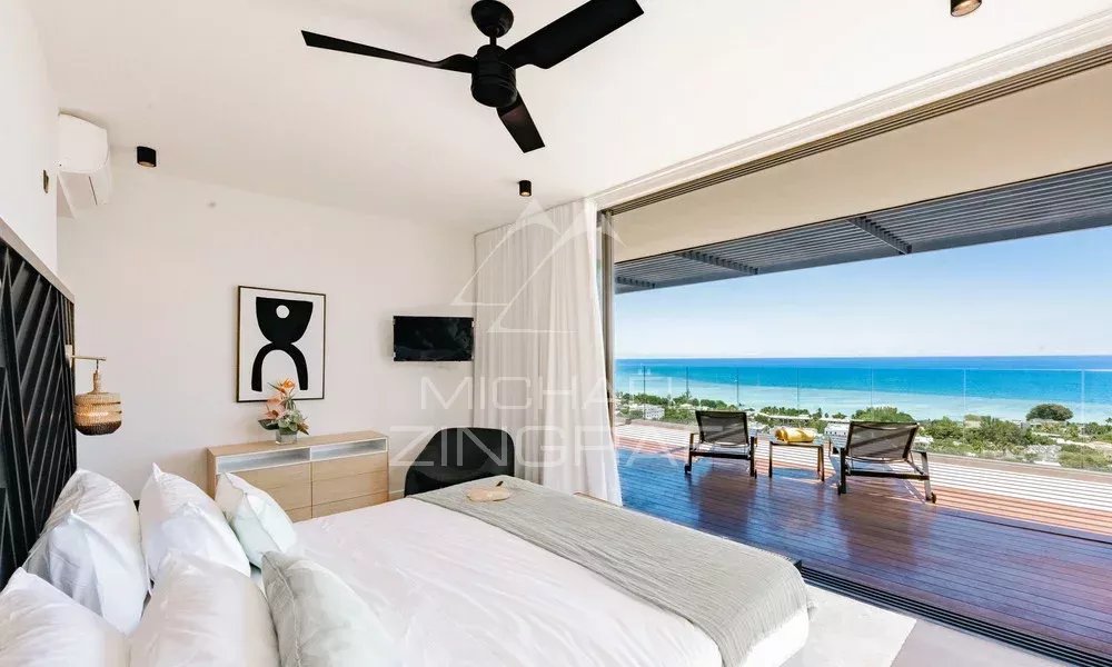 Chambre avec vue sur la mer dans une villa Chambre d'une villa avec vue sur la mer, lit king-size et accès à une terrasse.