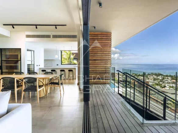 Intérieur moderne d'une villa avec vue sur la mer, comprenant salon et salle à manger.