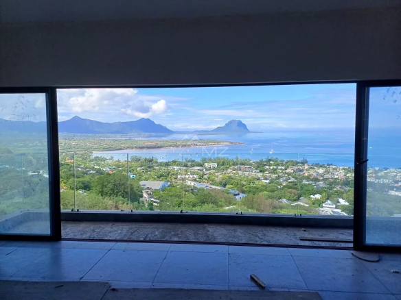 Vue panoramique depuis une villa avec grandes fenêtres, surplombant la mer et les montagnes à Rivière Noire.