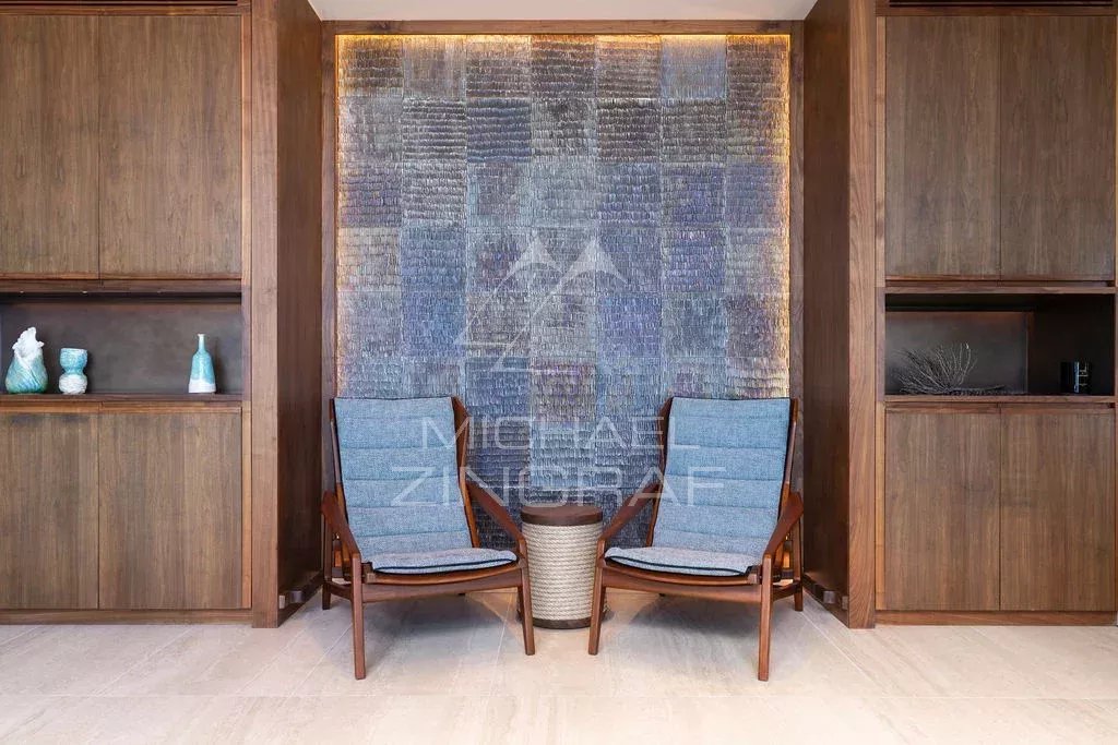 Intérieur d’un penthouse d’exception Intérieur d'un penthouse avec deux chaises en bois et un mur décoratif en verre.