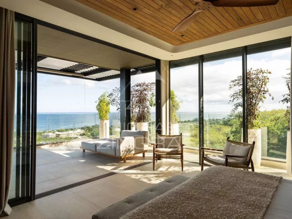 Intérieur d'un penthouse avec vue sur l'océan Indien, baigné de lumière naturelle.