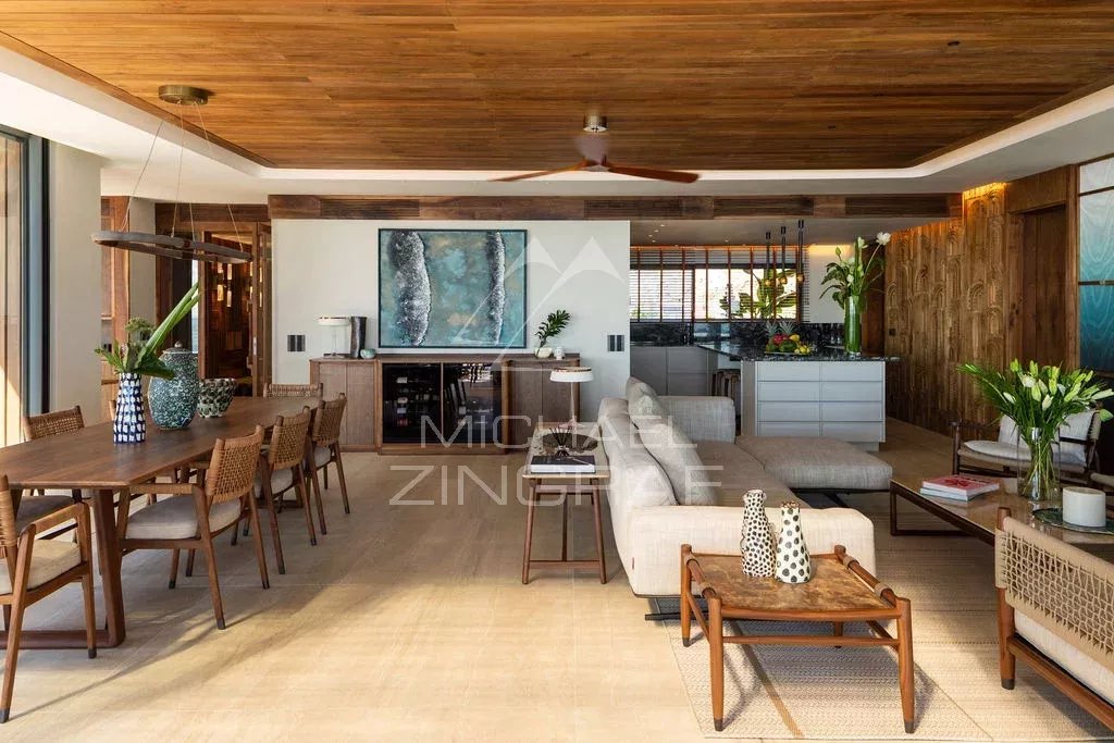 Intérieur d’un penthouse à Rivière Noire Intérieur d'un penthouse moderne avec mobilier en bois et grandes fenêtres donnant sur l'océan.