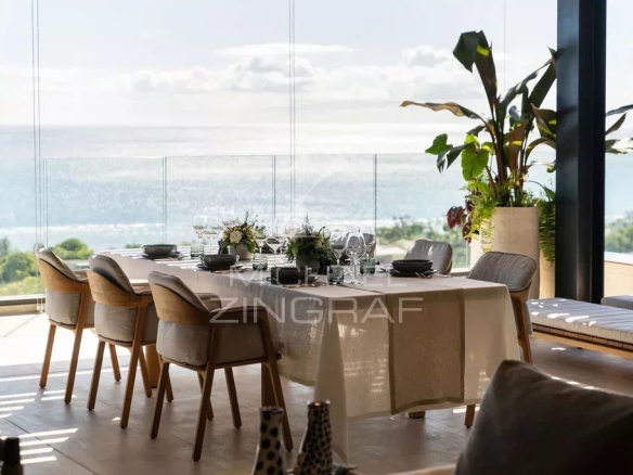 Salle à manger moderne avec vue sur l'océan Indien depuis un penthouse à Rivière Noire.