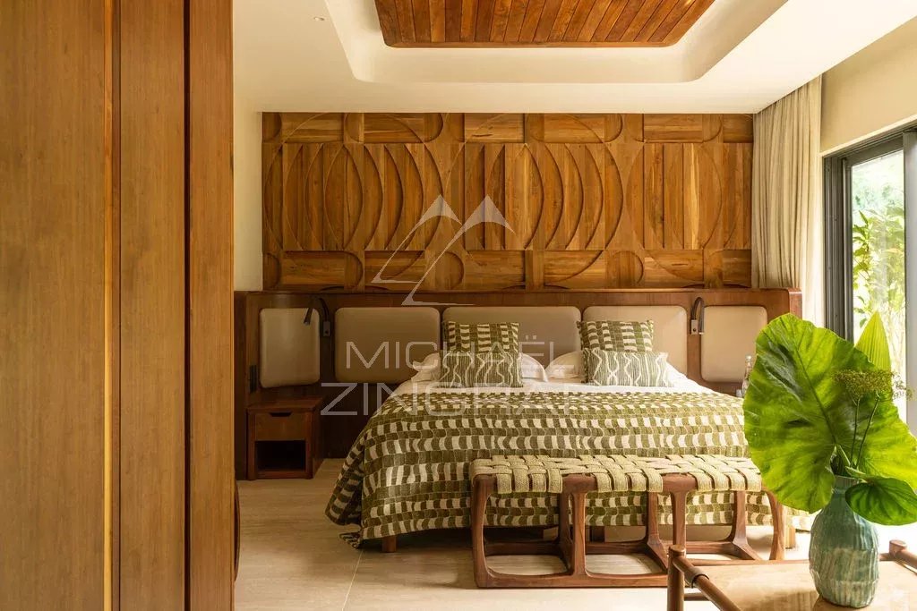 Chambre d’un penthouse d’exception Chambre d'un penthouse avec un lit en bois et des murs en bois sculpté.