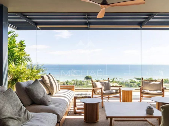 Intérieur d'un penthouse avec vue sur l'océan Indien, mobilier moderne et lumineux.