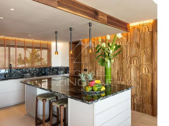 Cuisine moderne avec un îlot central et des éléments en bois, décorée de fleurs et de fruits.