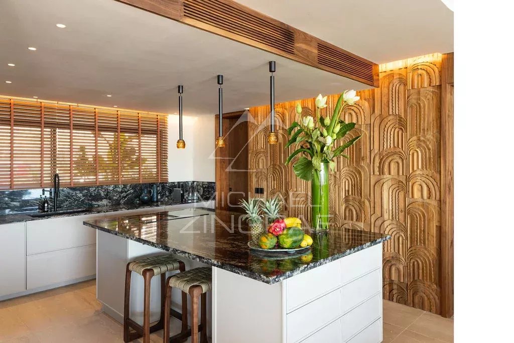 Cuisine du penthouse à Rivière Noire Cuisine moderne avec un îlot central et des éléments en bois, décorée de fleurs et de fruits.