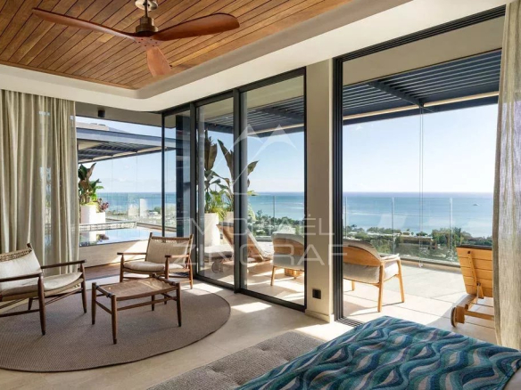 Intérieur d'un penthouse avec vue sur l'océan Indien, baigné de lumière naturelle.