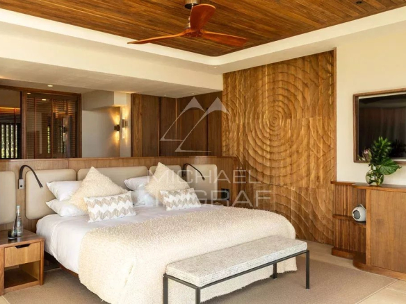 Chambre d'un penthouse avec lit king-size et décoration en bois à Rivière Noire.