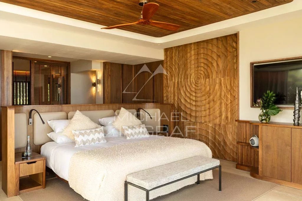Chambre de penthouse à Rivière Noire Chambre d'un penthouse avec lit king-size et décoration en bois à Rivière Noire.