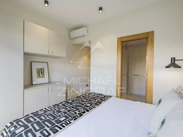 Chambre d'une villa contemporaine avec lit, armoire et salle de bain attenante.