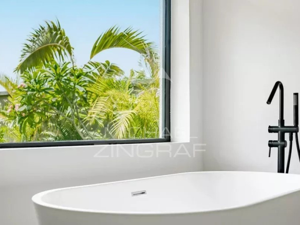 Salle de bain moderne avec baignoire et vue sur la végétation à Tamarin.