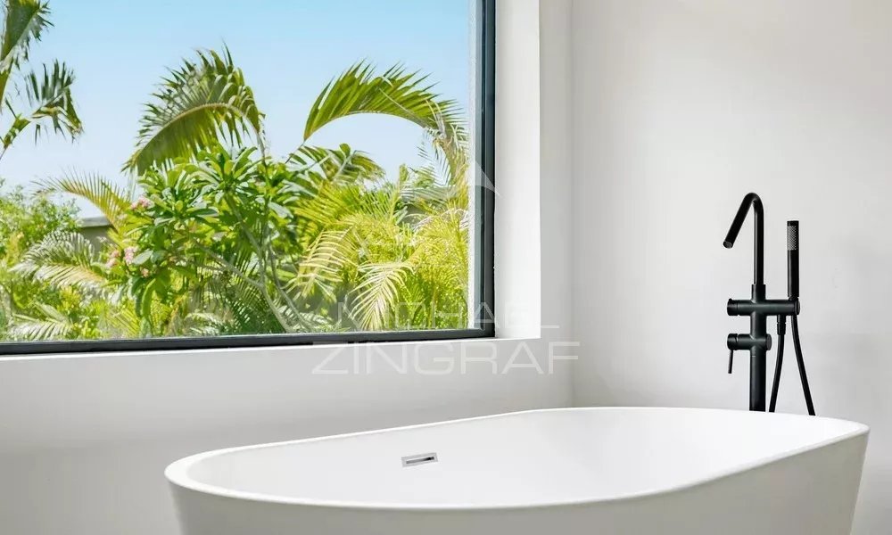 Salle de bain contemporaine à la Villa Hibiscus Salle de bain moderne avec baignoire et vue sur la végétation à Tamarin.