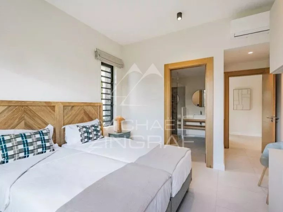 Chambre d'une villa contemporaine avec lit double et décoration moderne.