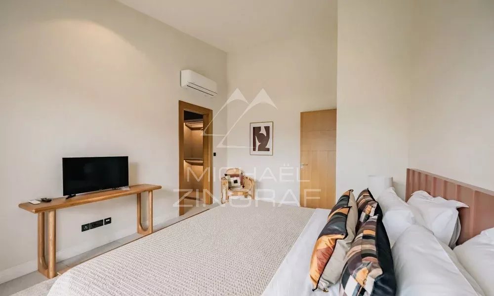 Chambre de la Villa Hibiscus à Tamarin Chambre d'une villa contemporaine avec télévision et lit, décorée de manière élégante.