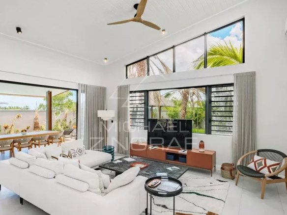 Intérieur moderne d'une villa à Tamarin avec salon lumineux et vue sur la terrasse.