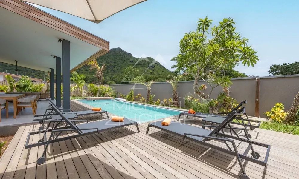 Villa Hibiscus à Tamarin Terrasse avec chaises longues et piscine à débordement dans une villa contemporaine à Tamarin.