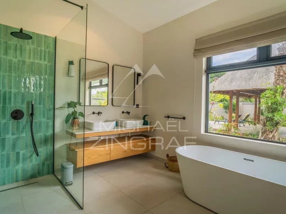 Salle de bain moderne avec douche en verre et baignoire, ouverte sur un jardin