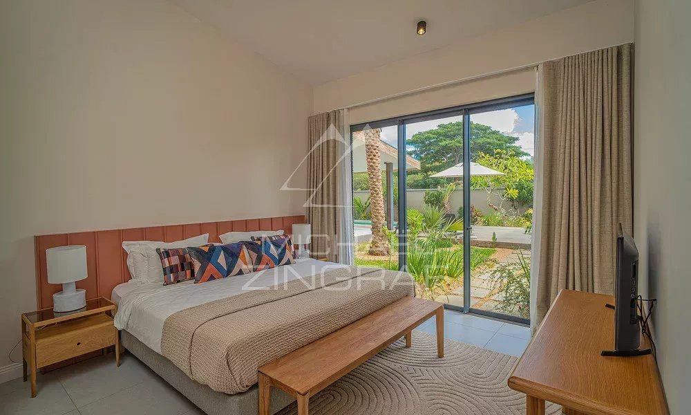 Chambre de la Villa Clusia à Tamarin Chambre d'une villa contemporaine avec accès à un espace extérieur verdoyant à Tamarin.