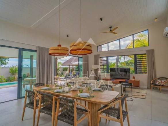 Intérieur moderne d'une villa avec salle à manger, salon et vue sur la piscine à débordement.