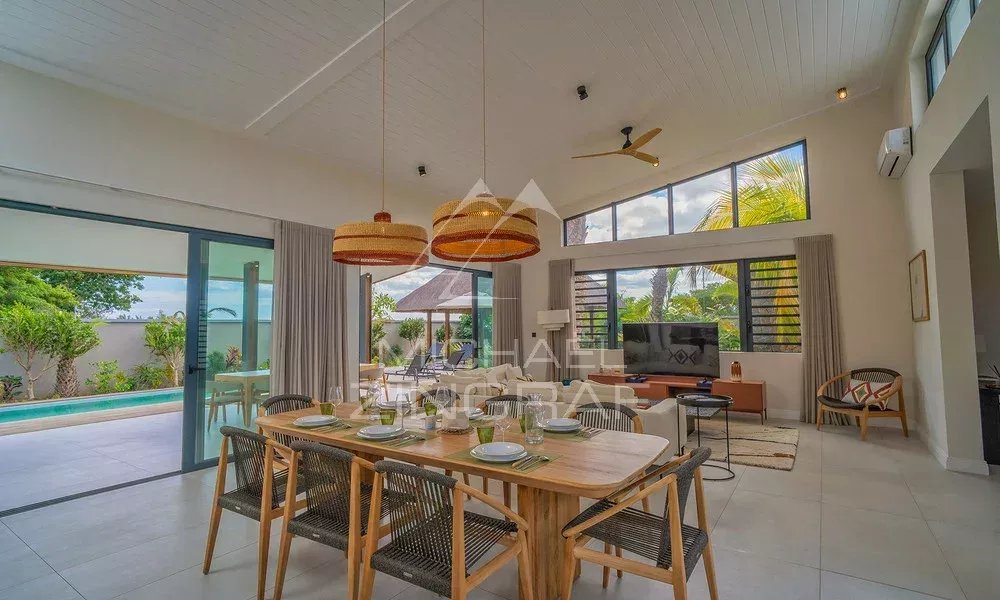 Intérieur de la Villa Clusia à Tamarin Intérieur moderne d'une villa avec salle à manger, salon et vue sur la piscine à débordement.